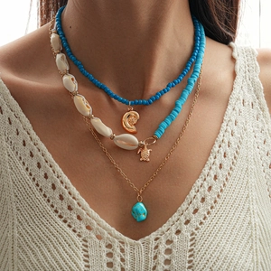 Close-up of bohemian triple-layer necklace with sea turtle charm and turquoise stone