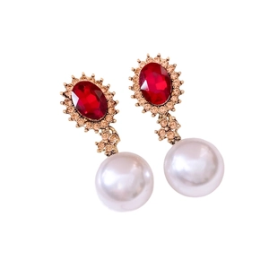 Vintage gold stud earrings with red oval gemstones and round white pearls in a pair