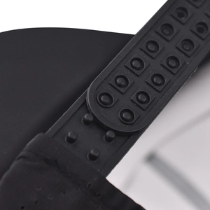 Dettaglio macro della chiusura snapback regolabile in plastica nera sul cappellino