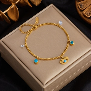 Dettaglio del bracciale in acciaio inossidabile dorato con occhio smaltato blu e cristalli