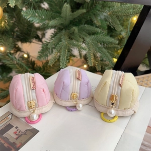 Detailed view of quilted headphone pouches in pink, purple, and yellow with pearl zippers