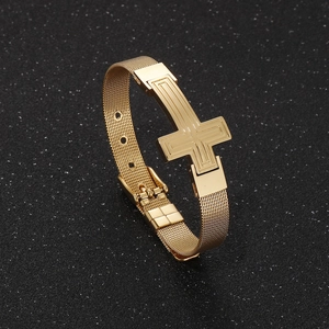 Macro shot of gold cross charm on adjustable mesh stainless steel bracelet for men