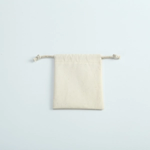 Natural cotton linen drawstring pouch for jewelry storage and gift packaging on grey background