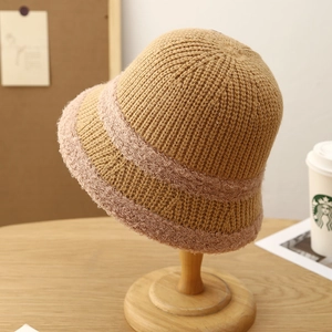 Detail of knitted khaki bucket hat featuring pink fuzzy decorative stripes on textures