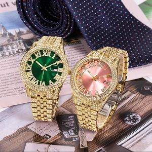 Detail of luxury gold watches with green and pink dials on vintage newspaper background