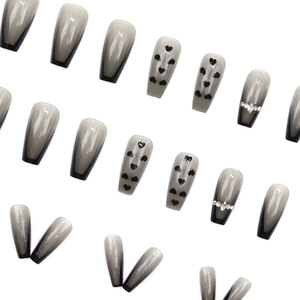 Long coffin press-on nails featuring grey black ombre, heart patterns and rhinestones