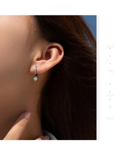 Detail of 925 silver hoop earring with pavé diamonds and a clear Moissanite pendant