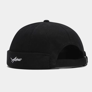 Detail of black cotton docker cap featuring white Asher embroidery and metal buckle