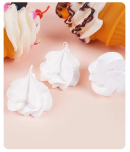 Macro shot of white miniature resin cream dollops for DIY craft sundaes on pink background