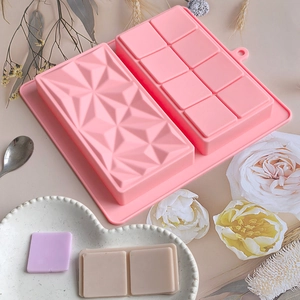 Macro detail of pink silicone mold with geometric diamond texture and square chocolate bar cells