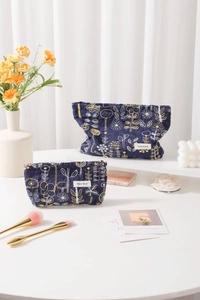 Detailed embroidery on blue cotton linen cosmetic bags with floral gold patterns