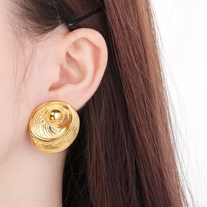 Macro shot of 18k gold plated stainless steel earrings with 3D swirl texture on model