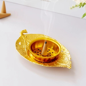 Middle Eastern golden leaf metal incense burner for home decor on white desktop
