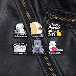Détail de pin's chat en émail rigolos attachés à une veste en cuir noir de haute qualité