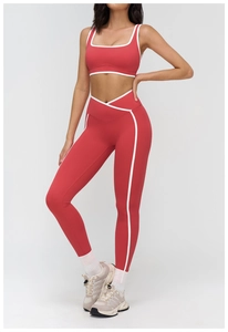 Detail of red yoga set featuring cross high waist leggings and white contrast piping