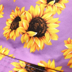 Close-up of purple bucket hat brim with vibrant yellow sunflower prints and sturdy stitching