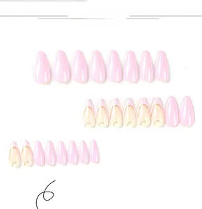 Detailed view of long almond press-on nails in pink and white with gold trim design