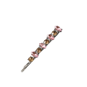 Close-up of metal hair clip with pink and brown rhinestones on a white background