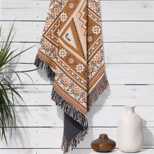 Detailed close-up of bohemian woven blanket with geometric patterns and fringe