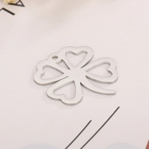 Macro shot of silver titanium steel four-leaf clover pendant with polished finish