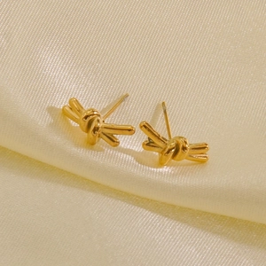Elegant 14K gold-plated stainless steel knot stud earrings on soft silk background