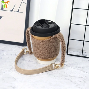 Plush sherpa coffee sleeve with detachable beige leather handle and gold hardware detail