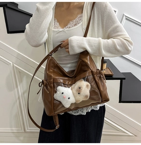 Brown faux leather tote bag featuring a clear PVC window with cute plush animal charms
