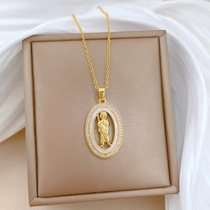 Collier ovale en acier titane doré avec nacre blanche et cristaux sur fond de soie blanche