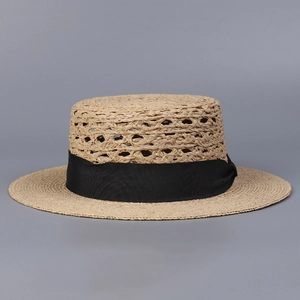 Detalle de sombrero boater de rafia con textura tejida y cinta negra elegante