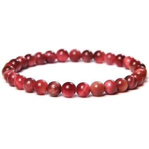 Macro view of polished red tiger eye beads with distinct cat-eye optical effect