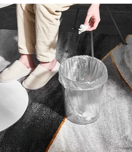 Detailed top view of a large transparent round waste bin on a modern geometric carpet