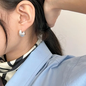 Detailed view of layered 925 sterling silver hoop earrings worn by a model