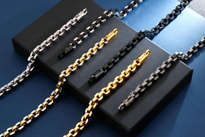 Detail of hex box chains in silver and gold tones with cylindrical metal clasps