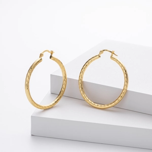 Detail shot of golden S925 sterling silver hoop earrings with twisted spiral texture