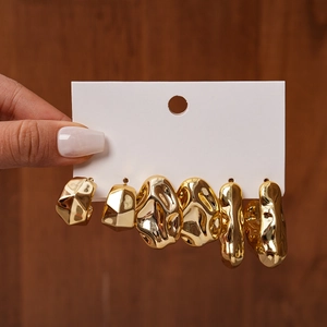 Detail of six-piece gold geometric earring set with irregular hammered textures