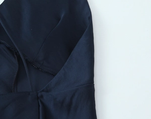 Detailansicht der dunkelblauen Satin-Stoffstruktur und hochwertigen Nähte am Kleid