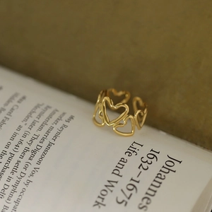 Bague cœur ajourée plaquée or 18 carats au design rétro sur des pages de vieux livre
