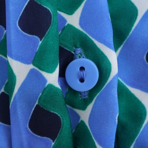 Chemise femme avec motif géométrique bleu et vert et détail d'un bouton rond assorti