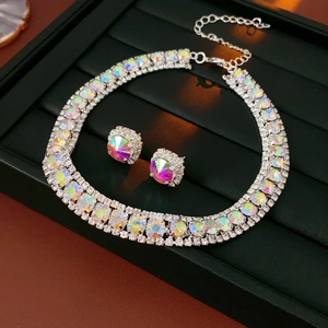Close-up of sparkling square rhinestone necklace and earrings set on a black tray
