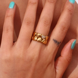Detailed close-up view of a gold heart band ring with a paved crystal heart accent