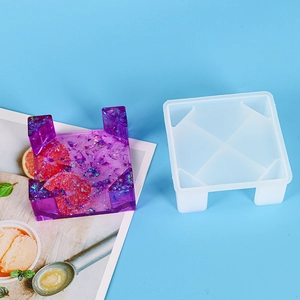 Macro detail of square silicone mold and purple resin coaster holder with glitter and fruit