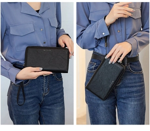 Detail of black pebbled leather RFID wallet clutch with wrist strap and metal logo
