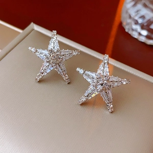 Dettaglio macro di orecchini a stella in argento con pavé di cristalli scintillanti