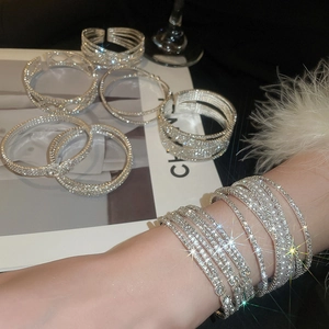Detail of silver crisscross pearl bracelet set with sparkling rhinestones on model