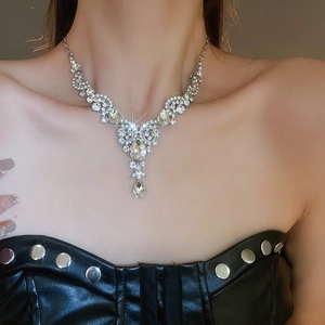 Close-up of luxury silver rhinestone teardrop necklace on model for evening dress