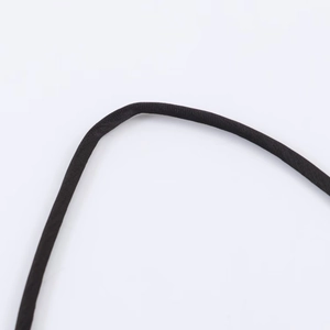 Macro view of black woven lace shoulder strap on sleek satin dress with fabric texture
