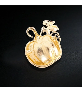 Detail of the golden pumpkin brooch back view showing metal texture and safety pin clasp
