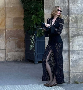 Dettaglio di un elegante abito nero in pizzo con spacco alto e maniche lunghe su modella