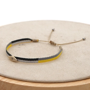 Detail of woven fabric bracelet with crystal evil eye charm and adjustable drawstrings