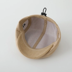 Beige suede beret for kids featuring breathable mesh lining and adjustable strap detail